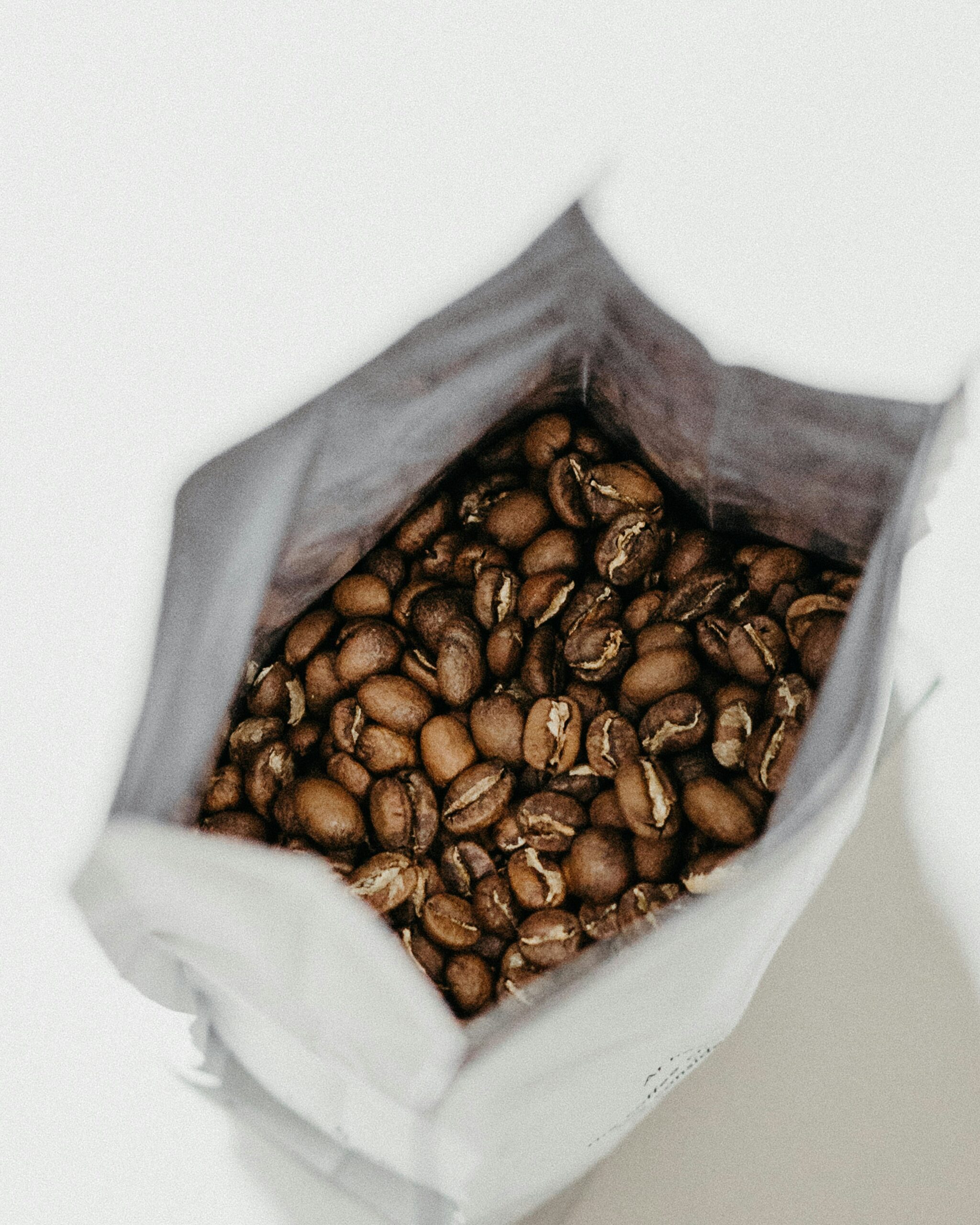 Close-up of roasted coffee beans inside an open coffee bag